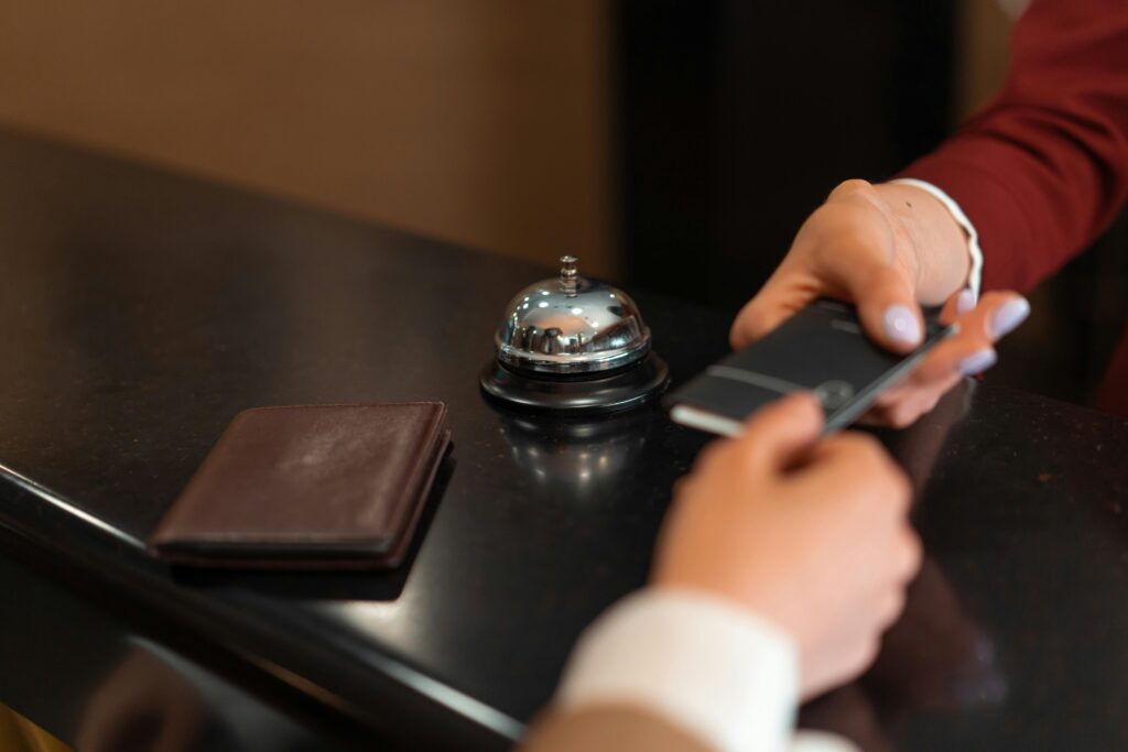 Mobile Key Technology A close-up of a hotel check-in process with a smartphone and card transaction at the reception desk.